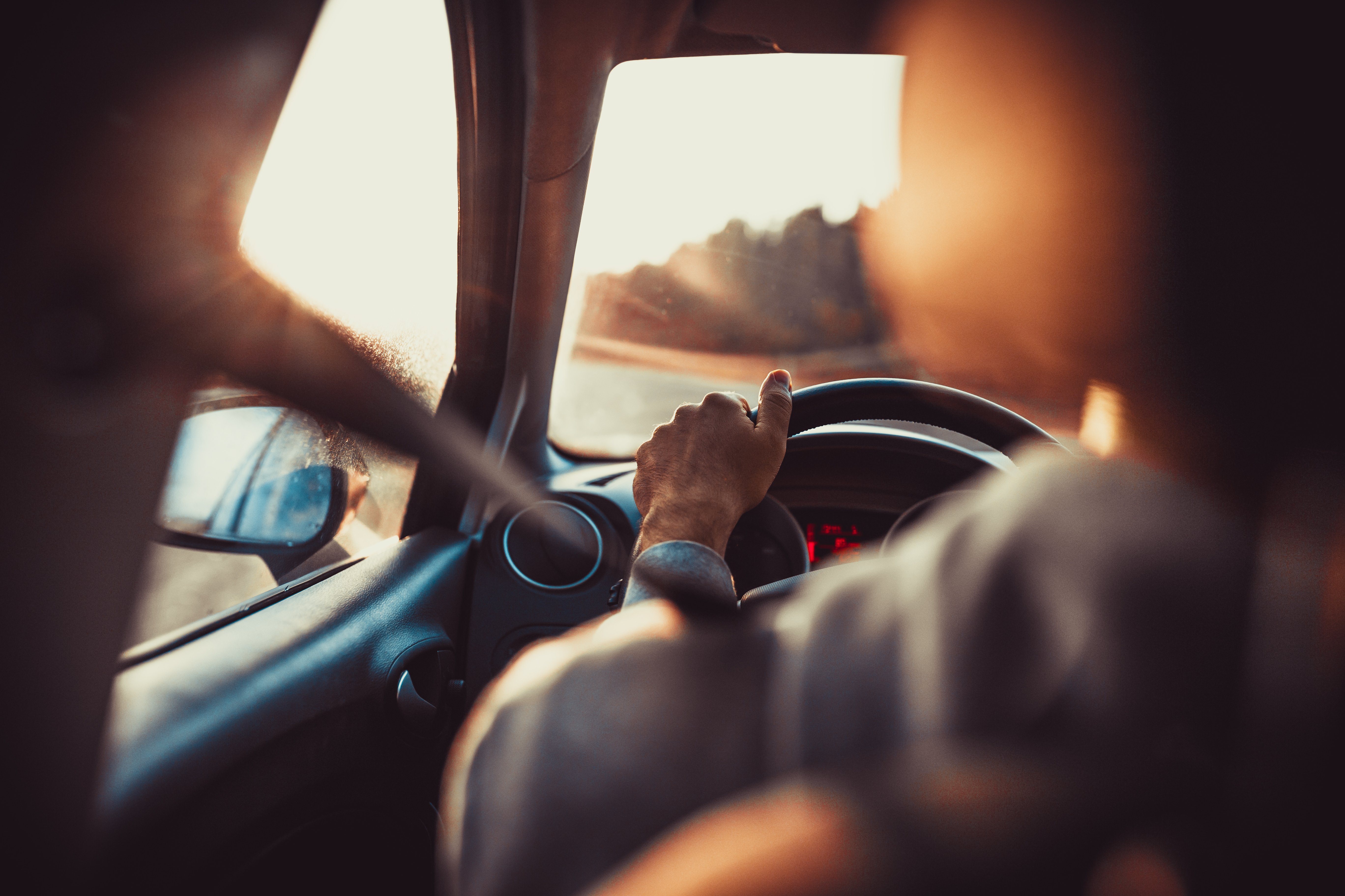 close up of a person's hand on a steering wheel